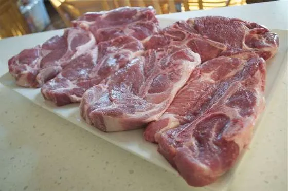 A platter covered with six one inch thick bone in pork steaks
